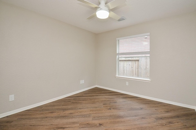 unfurnished room featuring wood finished floors, visible vents, ceiling fan, and baseboards