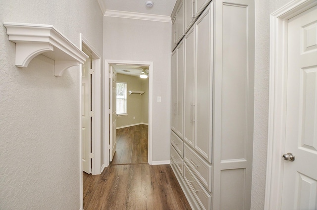 hallway with crown molding, dark wood finished floors, and baseboards