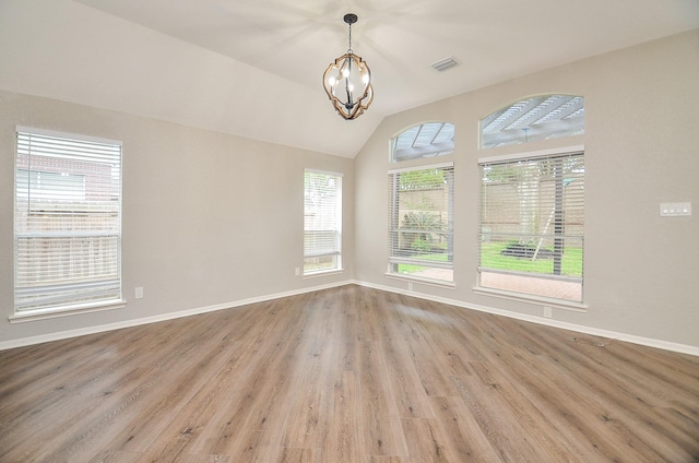 empty room featuring baseboards, visible vents, wood finished floors, and an inviting chandelier
