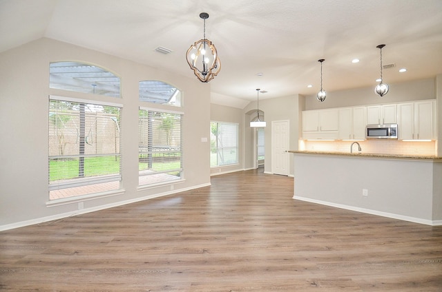 unfurnished living room with recessed lighting, light wood-type flooring, visible vents, a notable chandelier, and lofted ceiling