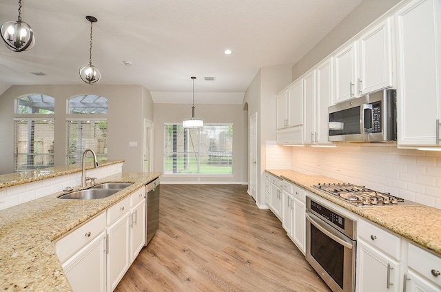 kitchen featuring light wood-style flooring, a sink, white cabinets, and appliances with stainless steel finishes