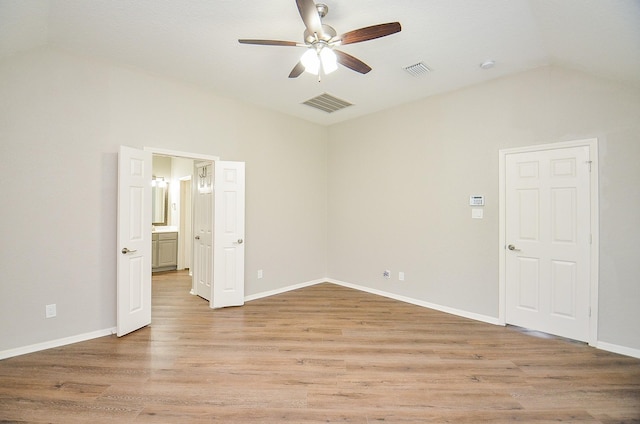 empty room featuring visible vents, ceiling fan, and vaulted ceiling