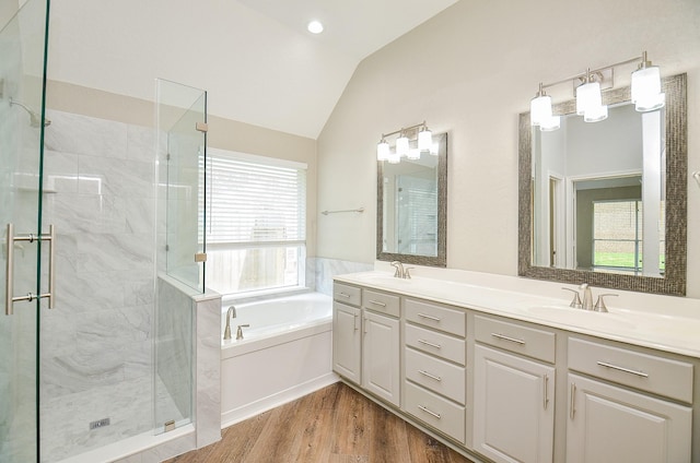 full bathroom featuring a shower stall, a garden tub, lofted ceiling, and a sink