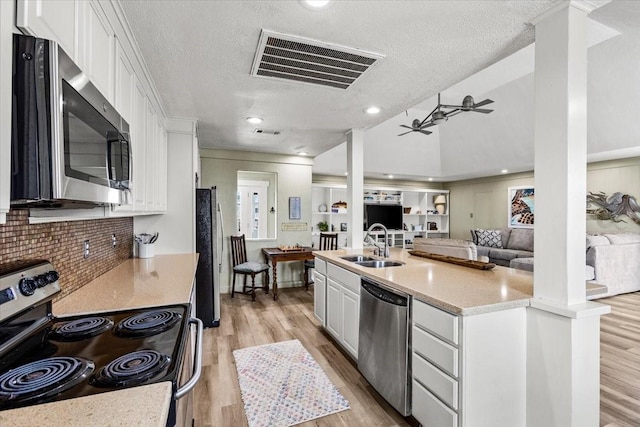 4311 Spanish Main, Jamaica Beach, TX 77554 - kitchen featuring stainless steel appliances, light wood-type flooring, visible vents, white cabinetry, and a textured ceiling