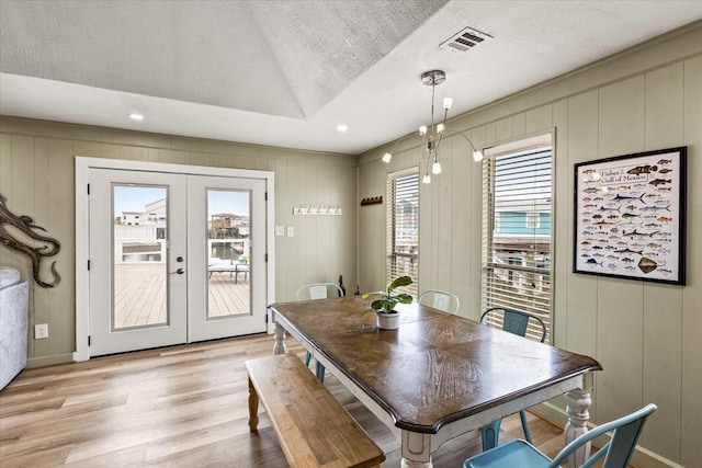 4311 Spanish Main, Jamaica Beach, TX 77554 - dining area featuring visible vents, french doors, a decorative wall, and light wood-style flooring