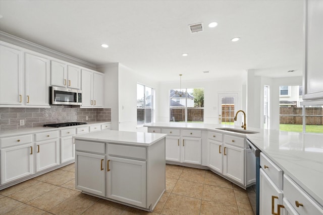 kitchen with appliances with stainless steel finishes, tasteful backsplash, white cabinets, and a sink