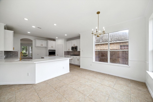 kitchen with recessed lighting, a sink, stainless steel appliances, a notable chandelier, and tasteful backsplash