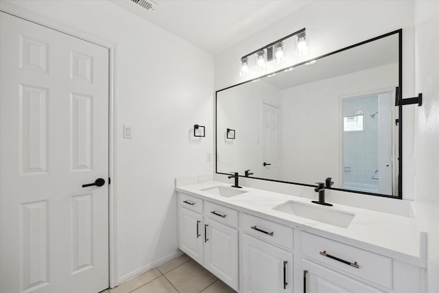 bathroom with double vanity, walk in shower, tile patterned flooring, and a sink