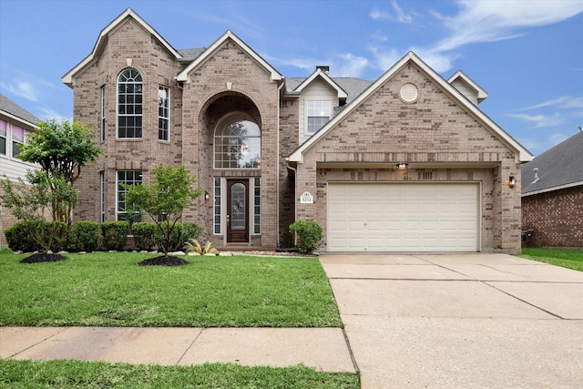 traditional home featuring a front lawn, concrete driveway, an attached garage, and brick siding