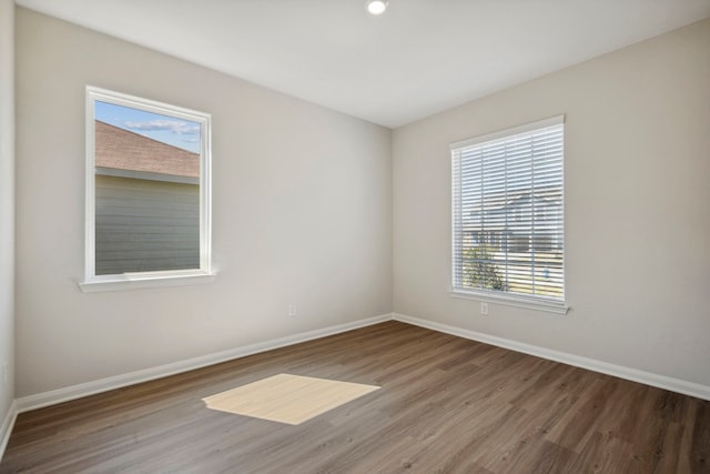 unfurnished room featuring baseboards and wood finished floors