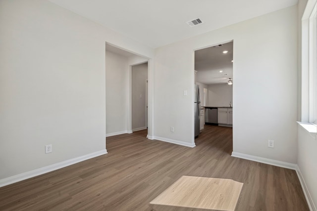 unfurnished living room with recessed lighting, visible vents, wood finished floors, and baseboards