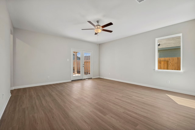 unfurnished room with wood finished floors, french doors, a ceiling fan, and baseboards