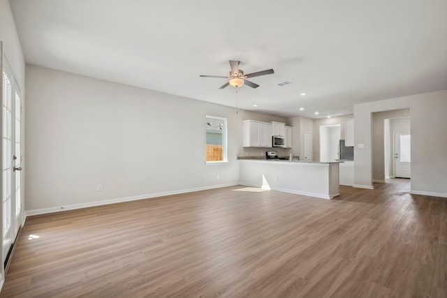 unfurnished living room with light wood finished floors, recessed lighting, a ceiling fan, visible vents, and baseboards