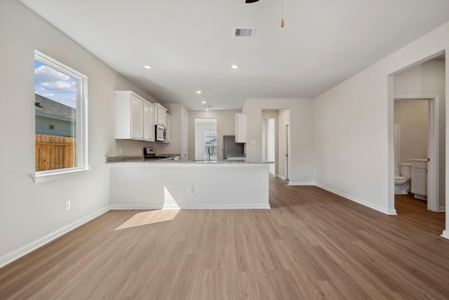 kitchen featuring light wood-style flooring, visible vents, appliances with stainless steel finishes, and white cabinetry