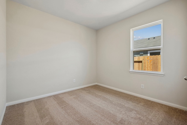 carpeted spare room featuring baseboards