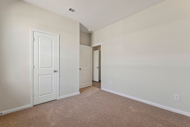 unfurnished bedroom featuring carpet, visible vents, and baseboards