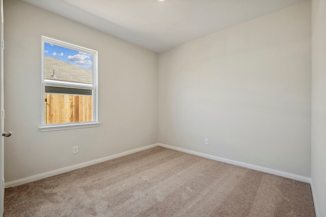 carpeted empty room featuring baseboards