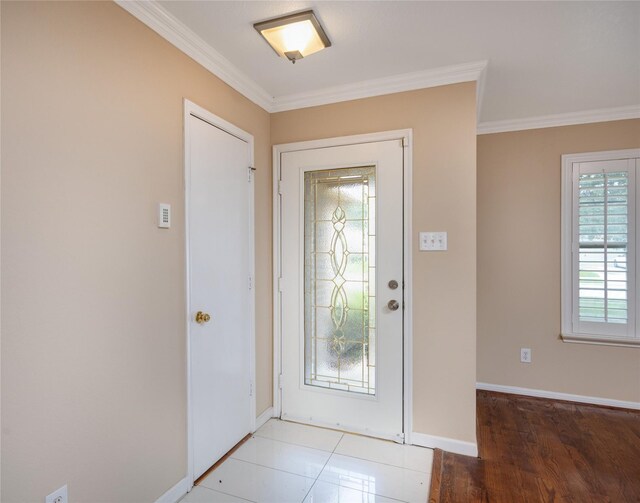 entryway featuring baseboards, ornamental molding, and wood finished floors