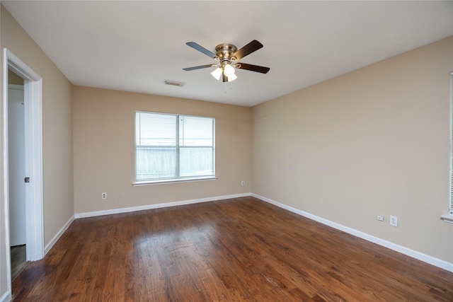 empty room featuring baseboards, visible vents, ceiling fan, and dark wood-type flooring