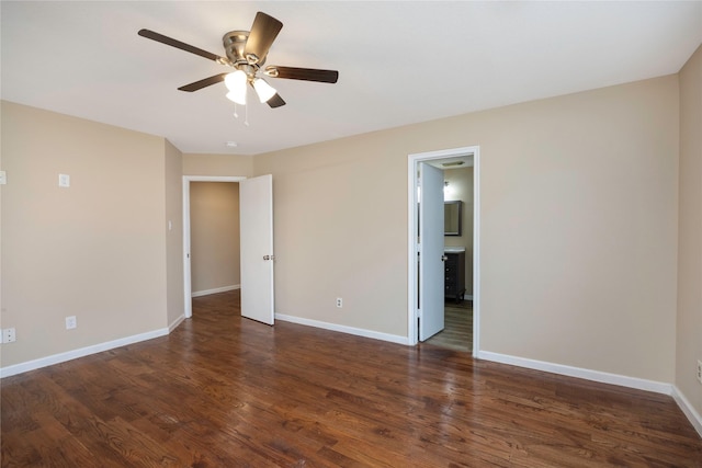 unfurnished bedroom featuring dark wood-style floors, ceiling fan, ensuite bath, and baseboards