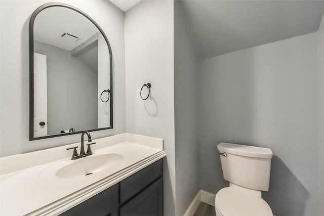 bathroom featuring visible vents, baseboards, toilet, and vanity