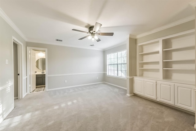 spare room with visible vents, a ceiling fan, crown molding, and light colored carpet