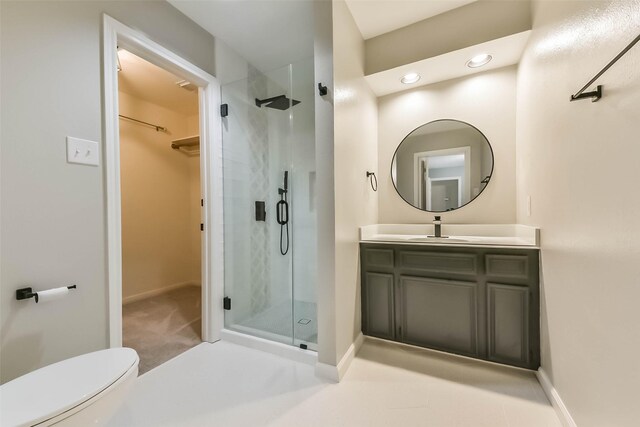 full bath with vanity, baseboards, a stall shower, and a spacious closet