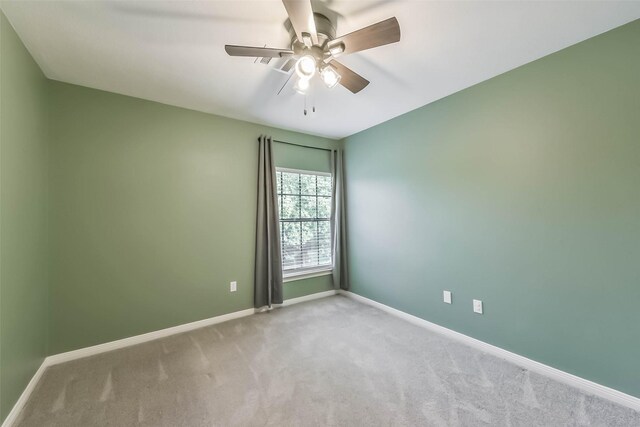 spare room with baseboards, a ceiling fan, and carpet