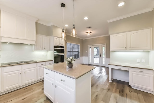kitchen featuring crown molding, black electric cooktop, double wall oven, and light wood finished floors