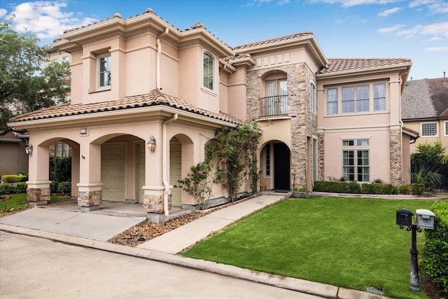 mediterranean / spanish home with a balcony, stucco siding, a tile roof, and a front yard
