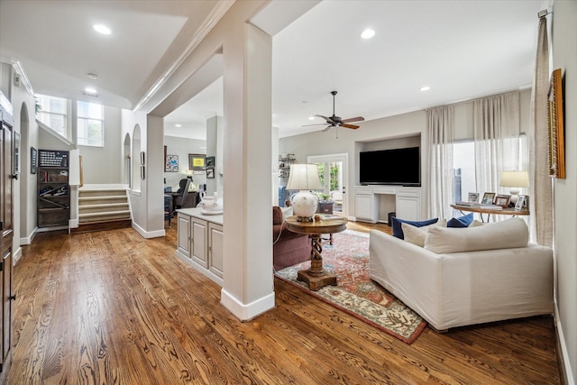 living room with stairs, ceiling fan, plenty of natural light, and wood finished floors