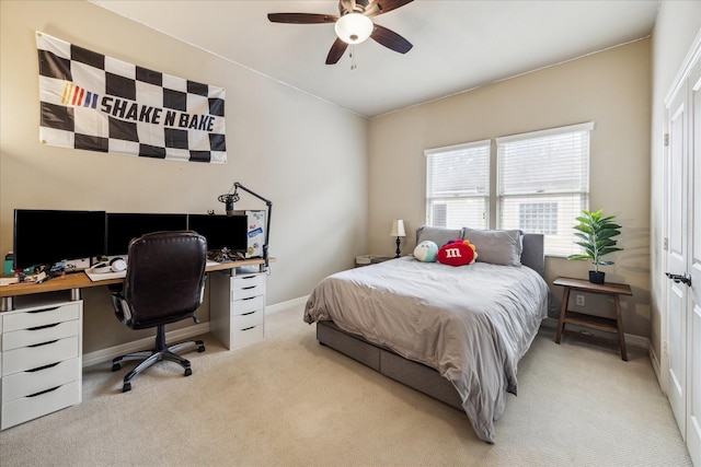 bedroom with a ceiling fan, baseboards, and light carpet