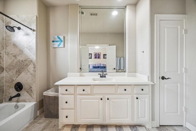 ensuite bathroom featuring visible vents, washtub / shower combination, ensuite bath, and vanity