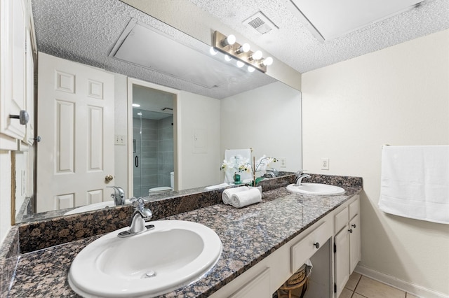 full bath with double vanity, a sink, tile patterned floors, and a shower stall