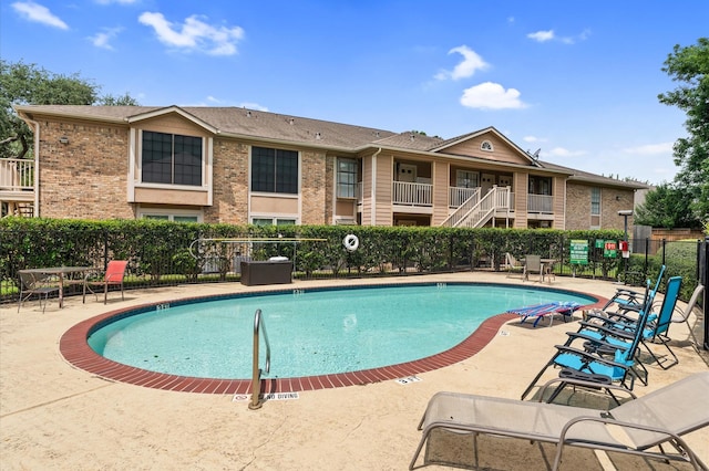 community pool with fence and a patio area