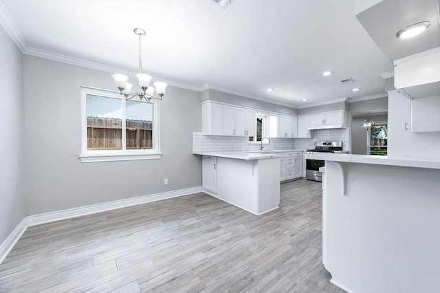 5807 Dumfries Dr, Houston, TX 77096 - kitchen featuring an inviting chandelier, white cabinetry, stainless steel gas range, a peninsula, and a kitchen breakfast bar