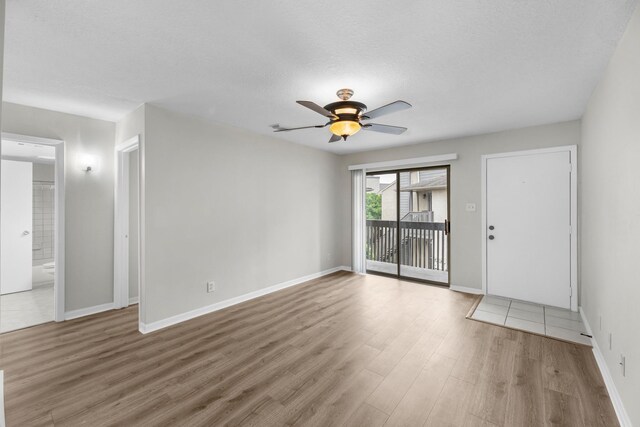 unfurnished living room with ceiling fan, wood finished floors, and baseboards