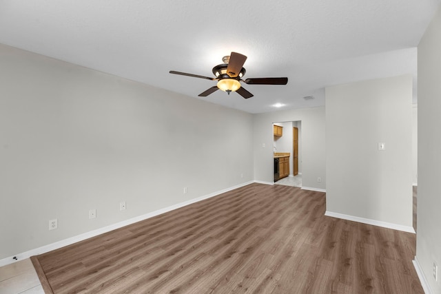 spare room featuring baseboards, visible vents, wood finished floors, and ceiling fan