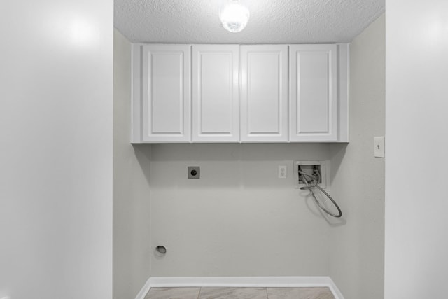 laundry area with cabinet space, hookup for an electric dryer, washer hookup, baseboards, and a textured ceiling