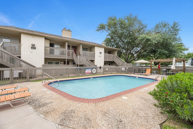 community pool with fence, a patio area, and stairs