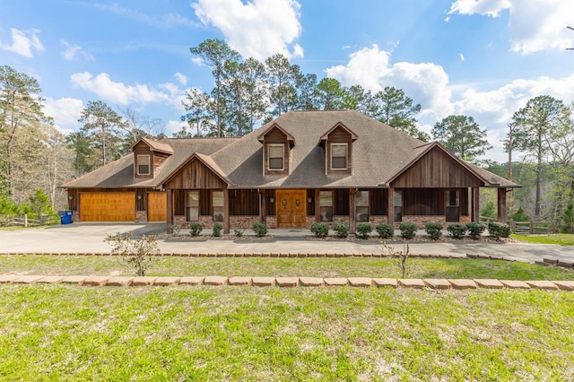 view of front of property with a garage, concrete driveway, a front yard, and stone siding