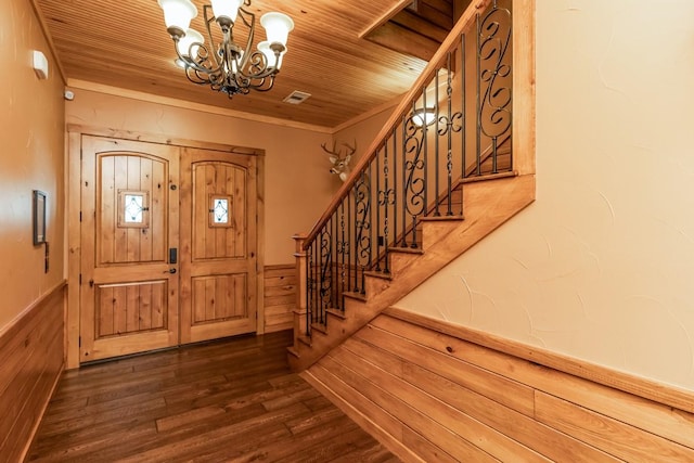 foyer featuring a wainscoted wall, wood walls, a chandelier, and wood ceiling