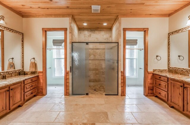 bathroom featuring recessed lighting, wooden ceiling, a tile shower, two vanities, and a wainscoted wall