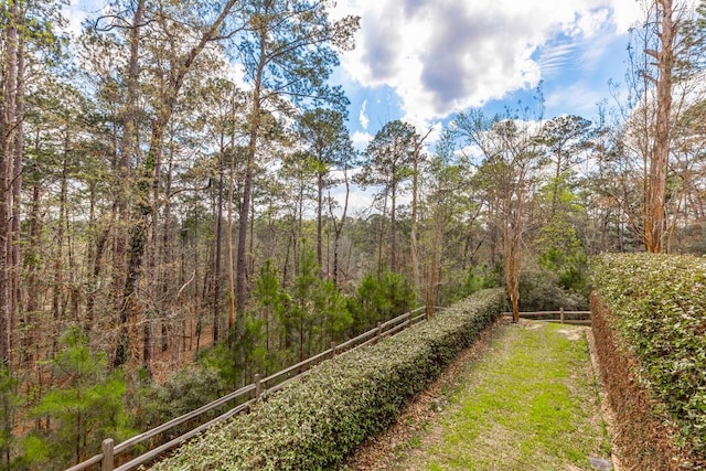 view of yard featuring fence and a forest view