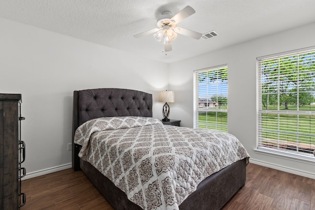 bedroom with wood finished floors, visible vents, ceiling fan, and baseboards