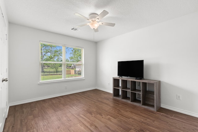 unfurnished living room with visible vents, wood finished floors, a ceiling fan, and a textured ceiling