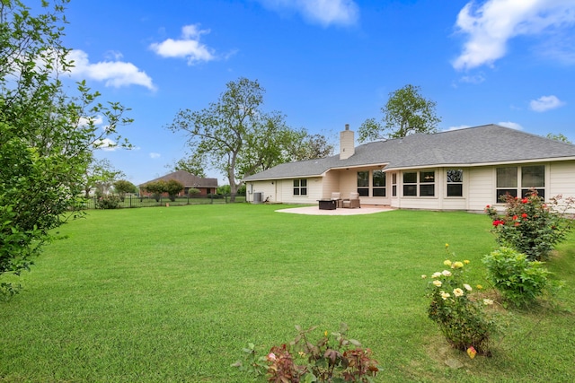 back of property with a patio, fence, a chimney, and a lawn