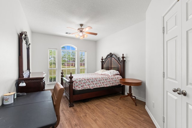 bedroom featuring light wood finished floors, visible vents, ceiling fan, and baseboards