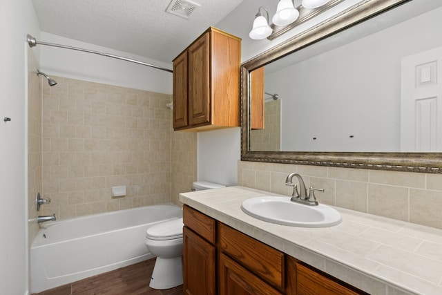 bathroom featuring decorative backsplash, shower / bath combination, toilet, visible vents, and wood finished floors