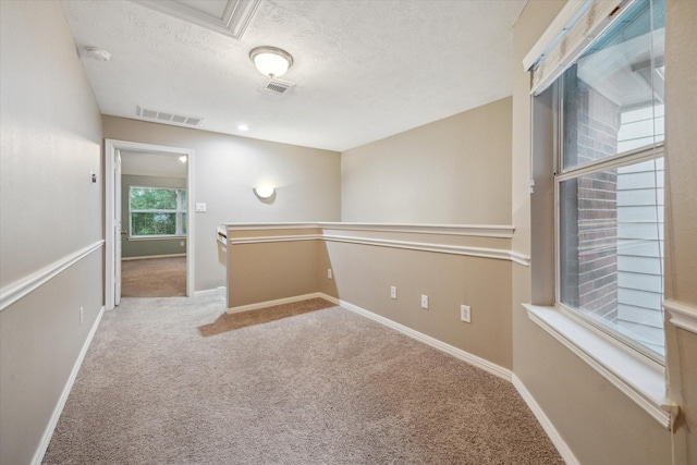 unfurnished room featuring carpet floors, a smoke detector, a textured ceiling, and baseboards